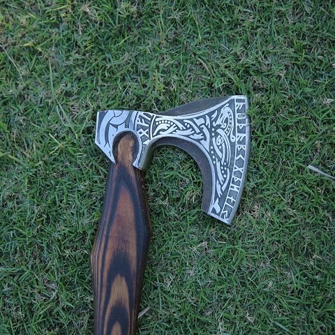 Close-up of the hand-forged carbon steel blade with detailed Viking engravings, showcasing craftsmanship and durability for outdoor use and historical reenactments