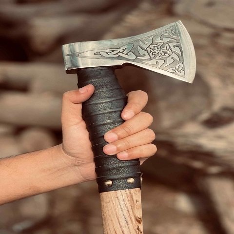 Man gripping Viking Survival Axe - ergonomic ashwood handle with leather wrap for comfortable camping use